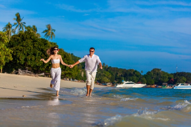 Casal correndo em uma praia tropical