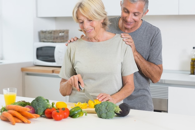 Casal cortando vegetais juntos