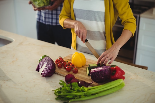 Casal cortar legumes na cozinha em casa