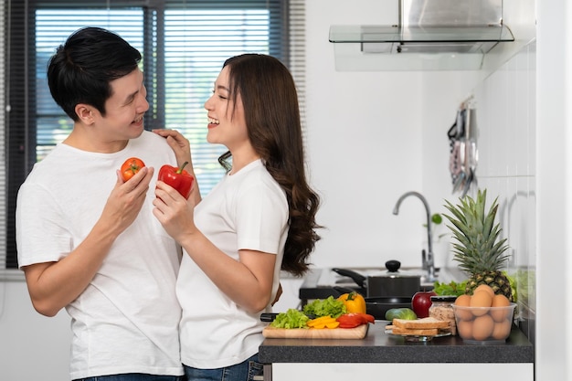 Foto casal cozinhando e preparando comida saudável de legumes na cozinha em casa