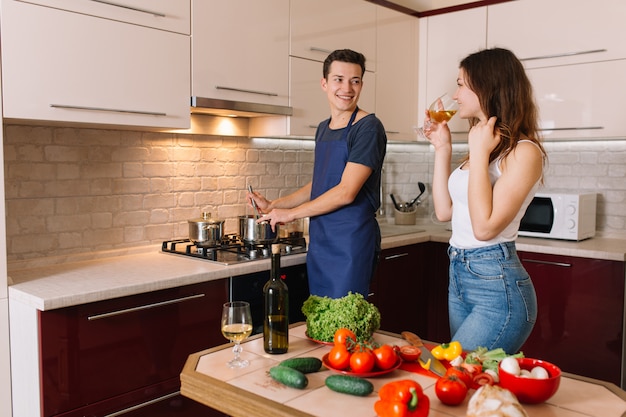 Casal cozinhar juntos e saborear o vinho.