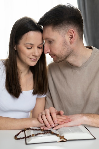 Casal cristão de tiro médio rezando