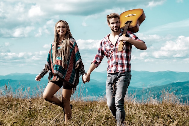 Casal curtindo a vida em fundo de belas montanhas. felizes amantes de mãos dadas.