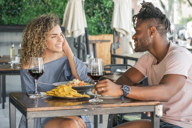 Casal curtindo e passando um bom tempo juntos, tendo um encontro em um restaurante.