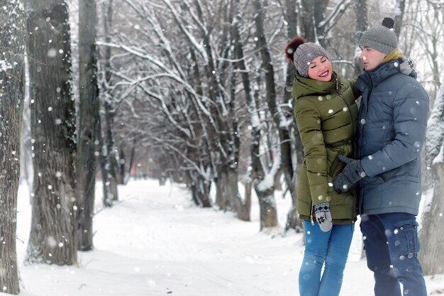 Casal da família caminhando na neve do inverno