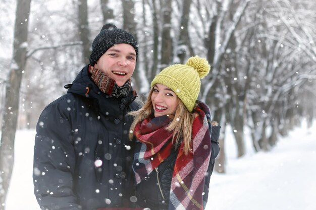 Casal da família caminhando na neve do inverno