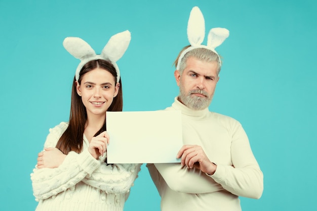 Foto casal da páscoa segurando um quadro branco em branco para o seu texto