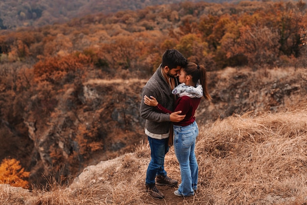 Casal dançando no ponto de vista e beijar. na floresta de fundo, outono.