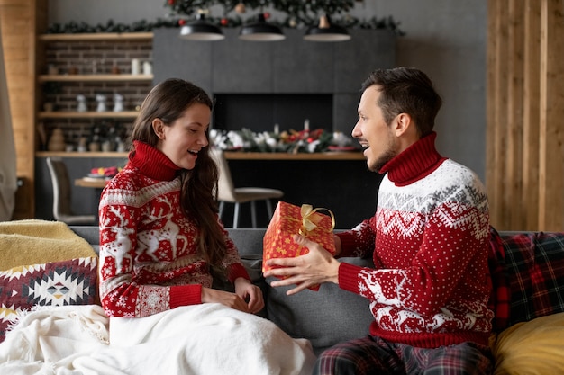 Casal dando presentes de Natal um ao outro