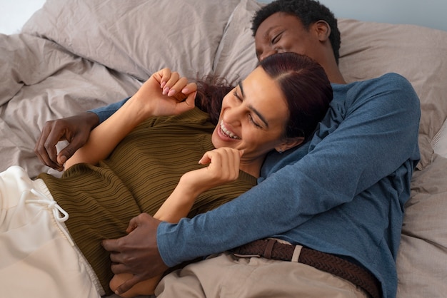 Foto casal de alto ângulo fazendo cócegas em casa