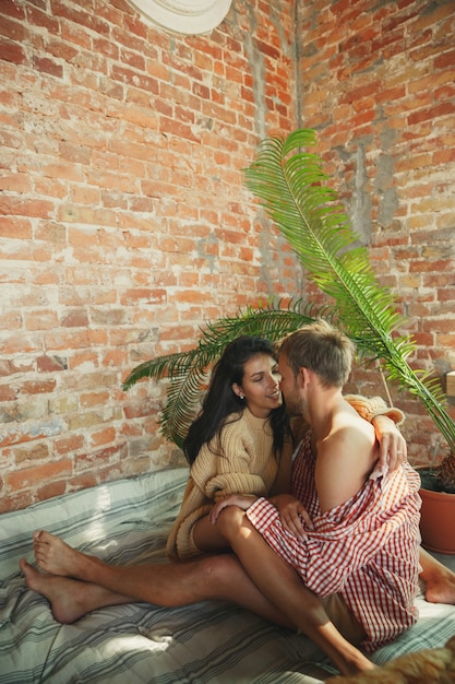 Casal de amantes em casa relaxando juntos. Homem caucasiano e mulher tendo fim de semana, parece terno e feliz. Conceito de relações, família, conforto outono e inverno. Emoções puras, se divertindo.