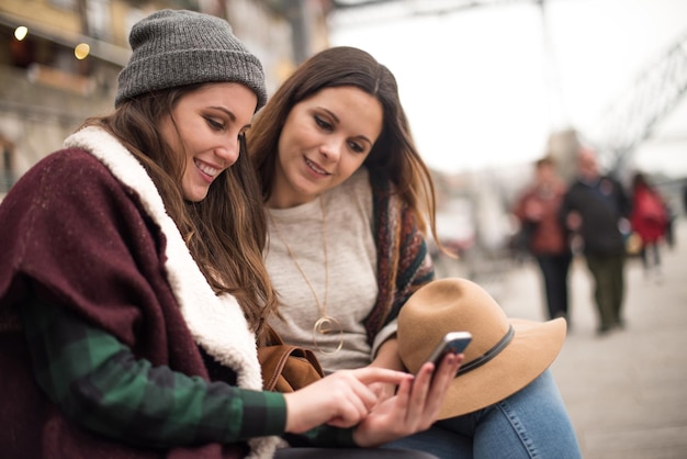 Casal de amigos com um smartphone na rua da cidade