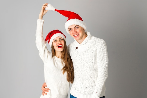 Casal de beleza alegre celebra o Natal no estúdio em fundo cinza