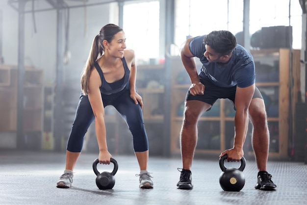 Casal de bem-estar forte fazendo exercícios de peso com kettlebell ou treinando dentro de uma academia Esportistas felizes ou motivação do treinador se exercitando com equipamentos de fitness para força muscular ou saúde