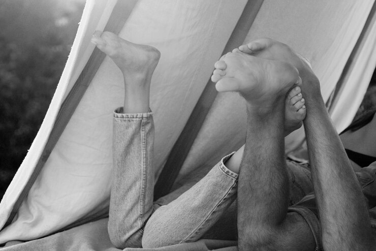 Foto casal de caminhantes acampando na natureza vista de pernas traseiras de casal em tenda melhor amigo foco nos pés romântico