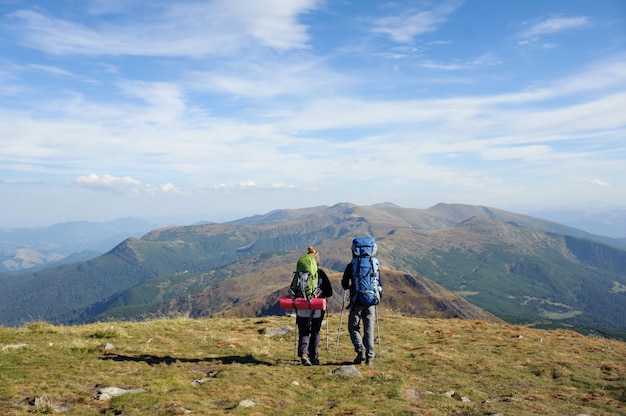 Casal de caminhantes nas montanhas dos cárpatos com mochilas