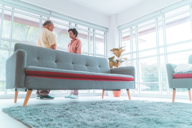 Casal de casamento sênior asiático está de pé na sala de estar pronto para o amor romântico dançando juntos.