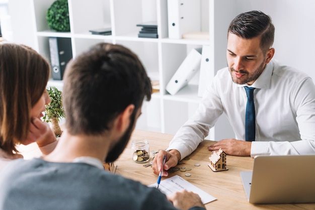 Casal de consultoria com agente imobiliário