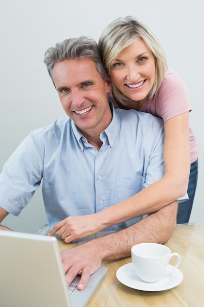 Casal de conteúdo usando laptop em casa