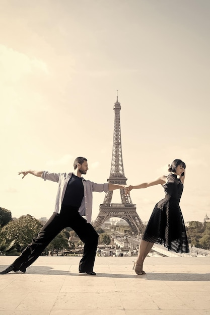 Casal de dança na frente da torre eifel em paris frança lindo casal de dança de salão em pose de dança perto do conceito de viagem romântica da torre eifel