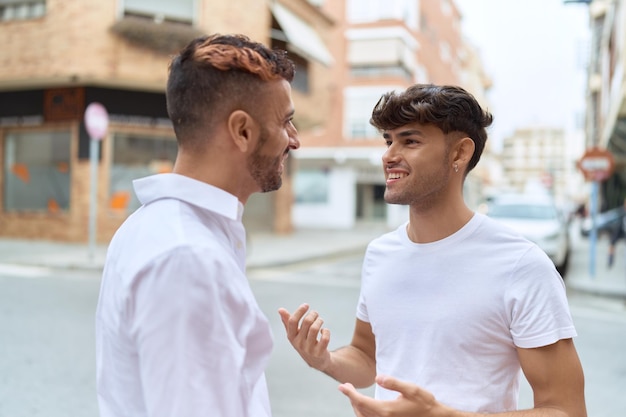 Casal de dois homens hispânicos conversando juntos na rua
