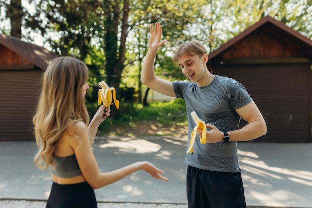 Casal de esportes feliz comendo comida saudável após o treino