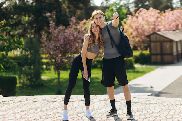 Casal de esportes fofo sorrindo para a câmera no parque