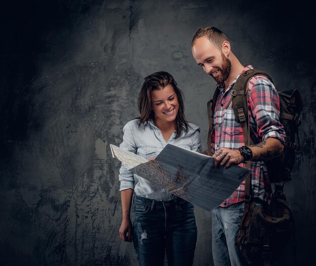 Casal de estilo urbano viajante olhando para o mapa.