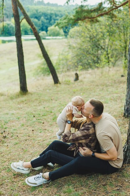 Casal de família feliz com filho recém-nascido na natureza Feliz jovem mãe e pai com um filho em uma caminhada na floresta O conceito de um casal feliz com um filho