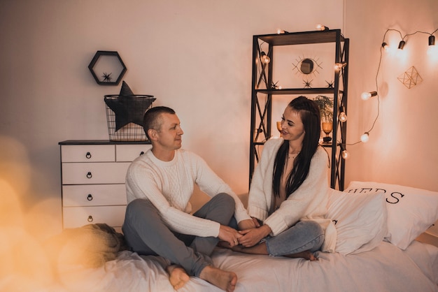 Foto casal de família feliz comemorando ano novo e natal em uma árvore de natal decorada e guirlandas