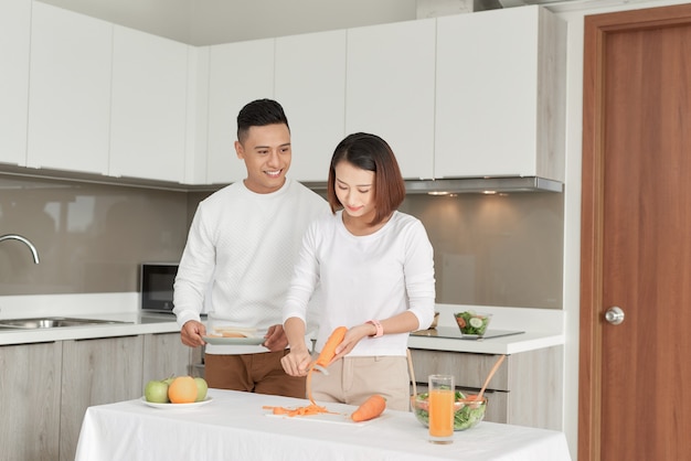 Casal de família feliz e sorridente cozinhando na cozinha do sótão.