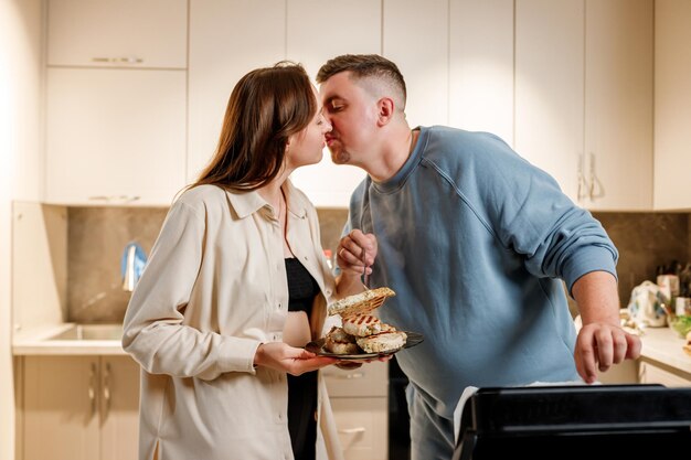 Casal de família feliz prepara um delicioso bife de carne suculento em uma grelha elétrica na cozinha moderna juntos Frite de carne nobre no torrador elétrico alecrim pimenta preta sal