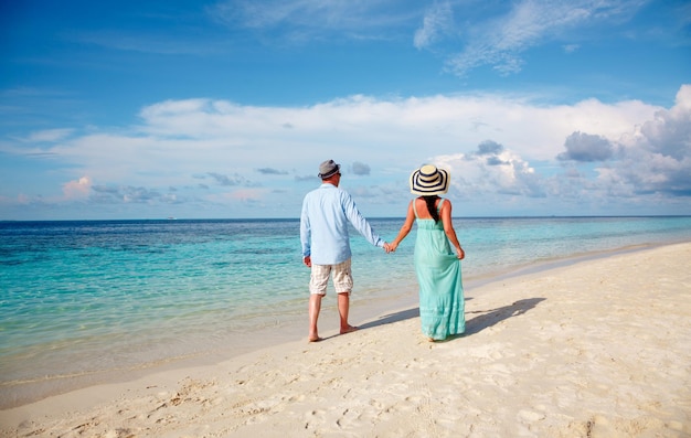 Casal de férias caminhando em uma praia tropical Maldivas. Homem e mulher caminhada romântica na praia.