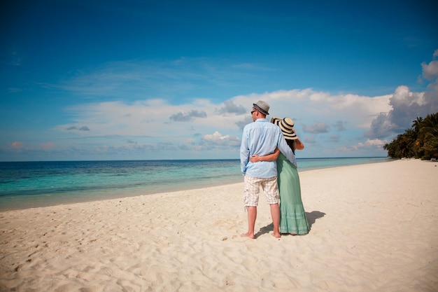 Casal de férias caminhando em uma praia tropical Maldivas. Homem e mulher caminhada romântica na praia.