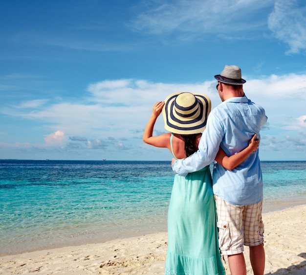 Casal de férias caminhando em uma praia tropical, Maldivas. Homem e mulher passeio romântico na praia.