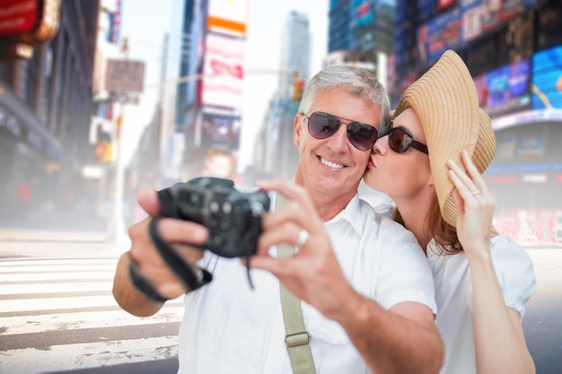 Casal de férias tirando foto contra a rua embaçada de Nova York