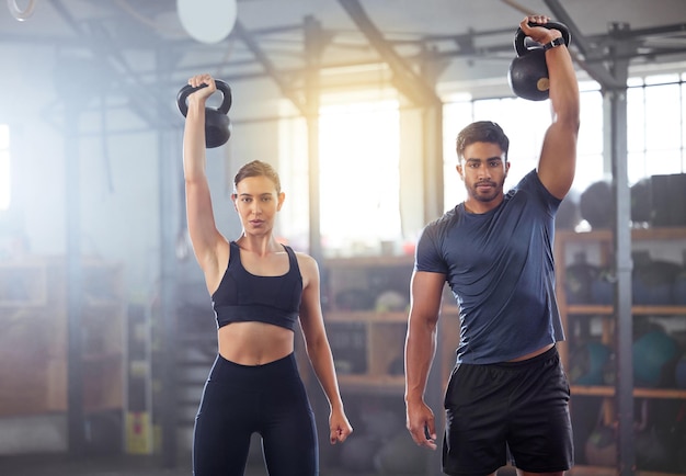 Casal de fitness fazendo um exercício de treino de kettlebell ou treinando em uma academia Desportista em forma de mulher ou homem com forte aderência se exercitando usando equipamentos de ginástica para construir músculos e força do antebraço