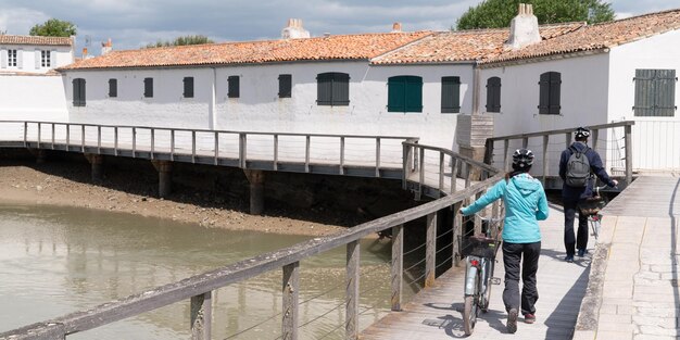 Casal de homem e mulher andando de bicicleta nas ciclovias da ilha de Re no cabeçalho do modelo de banner da web