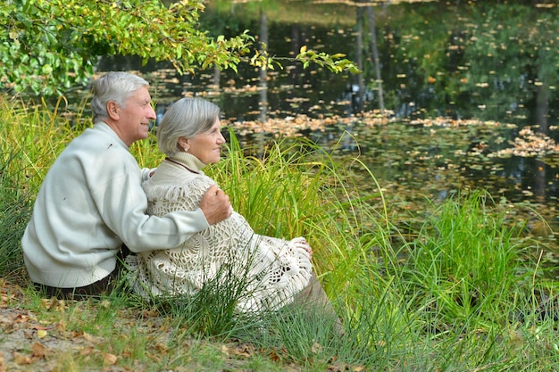 Casal de idosos à mesa na floresta de outono