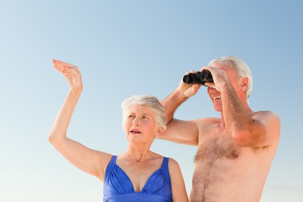 Casal de idosos assistindo pássaros na praia