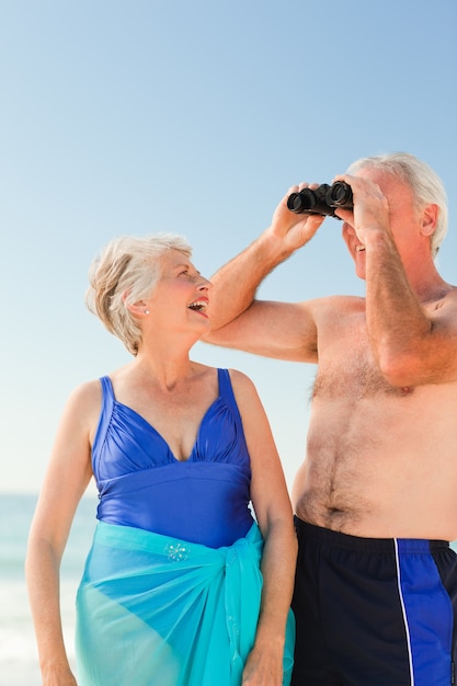 Casal de idosos assistindo pássaros na praia