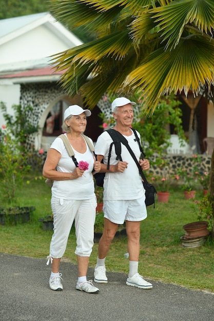 Casal de idosos ativos com mochilas na jornada