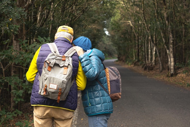 Casal de idosos desfrutando da natureza ao ar livre em uma floresta de montanha caminhando na estrada seguindo um mapa