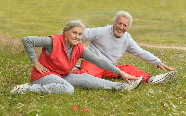 Casal de idosos em forma feliz se exercitando no parque outono