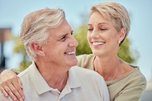 Casal de idosos feliz abraça o sorriso e ama o sol juntos nas férias de aposentadoria ou no verão ao ar livre Homem sênior unindo mulher com cuidados de felicidade e abraço durante as férias para relaxar na Flórida