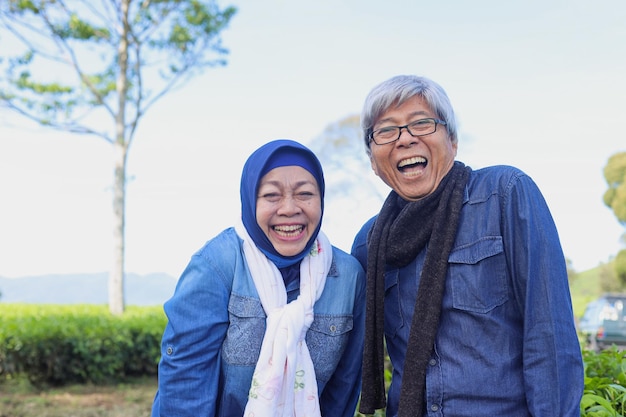 Casal de idosos feliz e saudável rindo da plantação de chá Grande sorriso dentes brancos