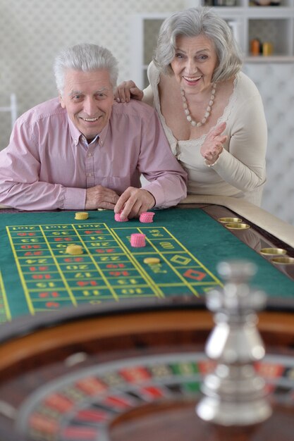 Casal de idosos feliz jogando com fichas de cassino