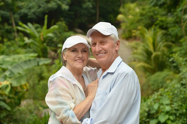 Casal de idosos felizes em um jardim tropical ao ar livre