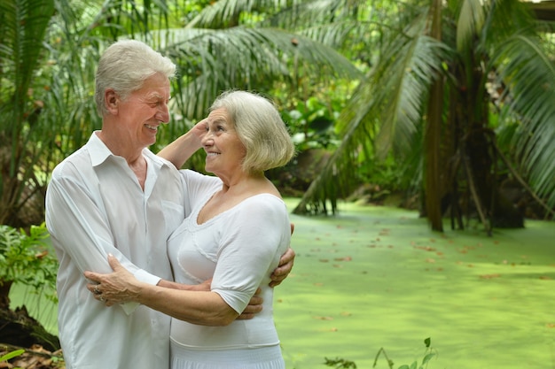 Casal de idosos felizes em um jardim tropical ao ar livre