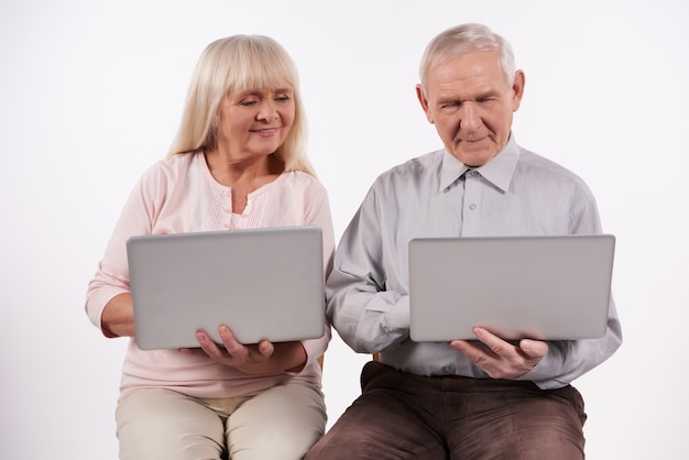 Casal de idosos interage com o laptop.